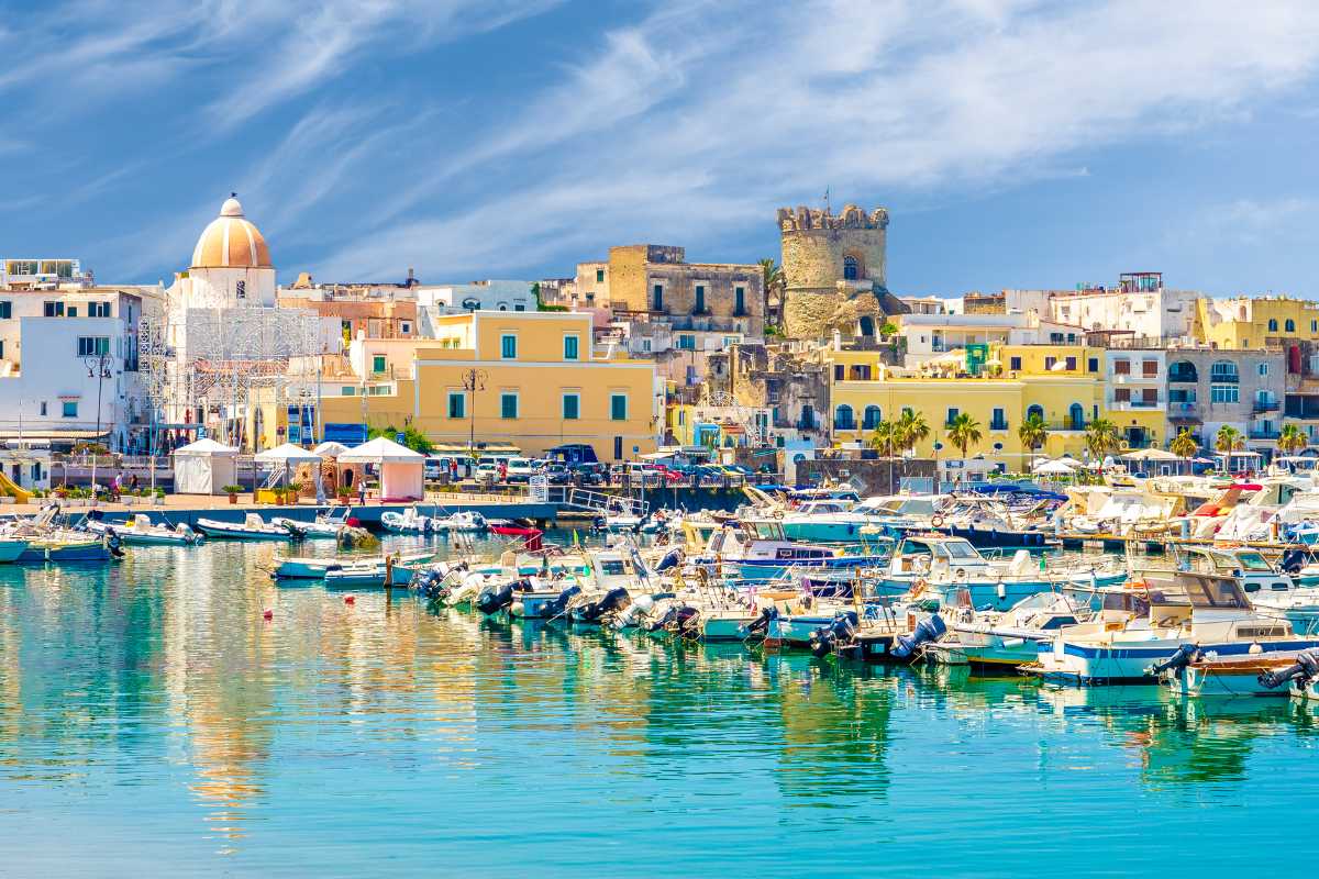 Vista panoramica dal Castello Aragonese al tramonto, con il borgo di Ischia Ponte in primo piano, atmosfera mediterranea autentica, Ischia